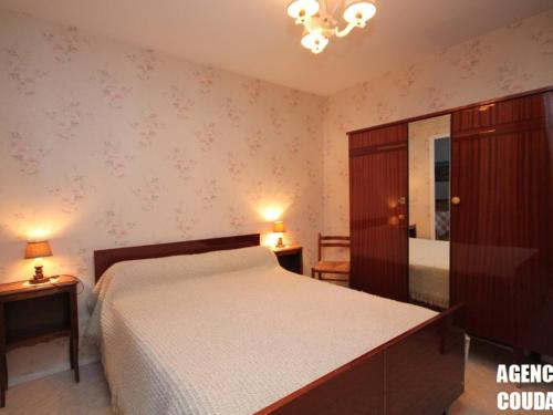 une chambre avec un lit, une commode et un miroir dans l'établissement Charmant T2 avec balcon exposé Ouest, parking privé, au Mont-Dore, proche centre et Thermes - FR-1-608-190, à Le Mont-Dore