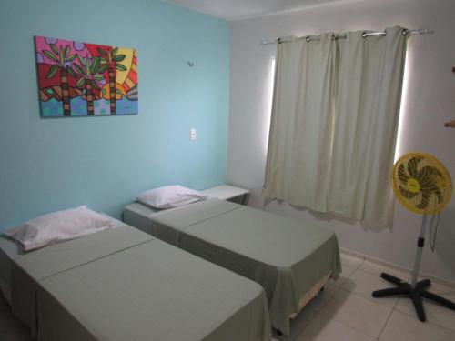 a room with two beds and a fan in it at Flats Condominio Professor Wilson in Teresina