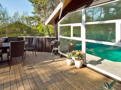 a patio with a table and a swimming pool at 8 person holiday home in Gilleleje in Gilleleje