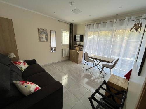 a living room with a couch and a table at Appartement au calme dans un espace arboré in Tourrettes-sur-Loup