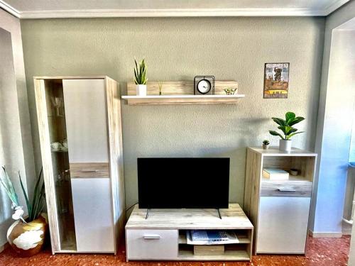 a living room with a tv on a shelf at Apartamento La Zahora - Alcañiz in Alcañiz