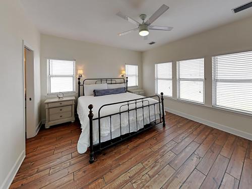 een slaapkamer met een bed en een plafondventilator bij Muskoka C in Gulf Shores