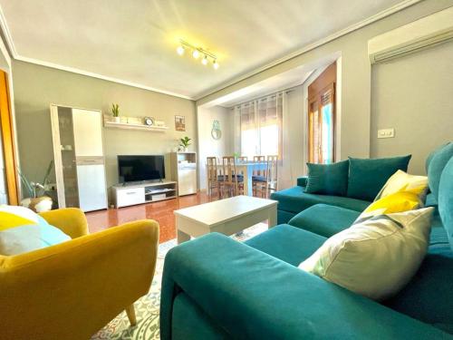 a living room with blue couches and a television at Apartamento La Zahora - Alcañiz in Alcañiz