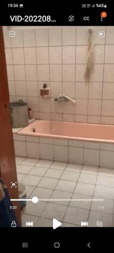 baño con bañera rosa y suelo de baldosa. en Akçatepe, en Akcaabat