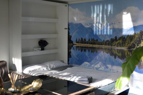 a bedroom with a wall mural of a lake and mountains at 1 Bedroom Guest House with Sauna and Steam Room in Kent