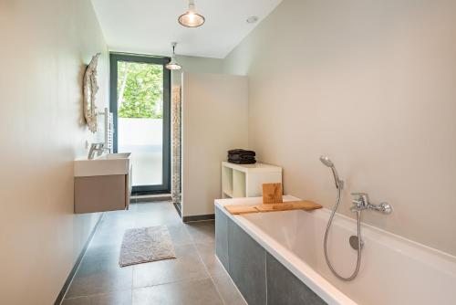 a bathroom with a bath tub and a sink at Villa Merici in Bergen