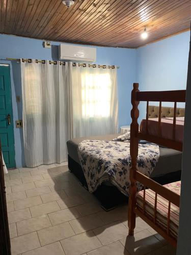 1 dormitorio con cama y ventana en Pousada Neide, en São Gabriel