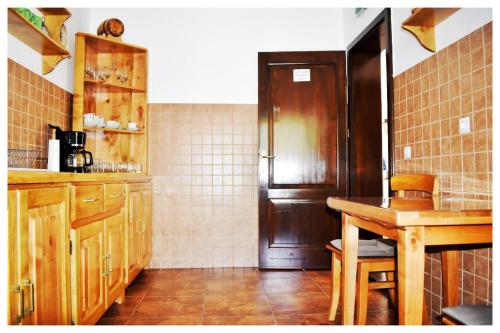 アルバクにあるPensiunea Poienitaのキッチン(木製キャビネット、テーブル、冷蔵庫付)