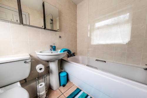 a bathroom with a sink and a toilet and a bath tub at Lynam House in Stoke on Trent