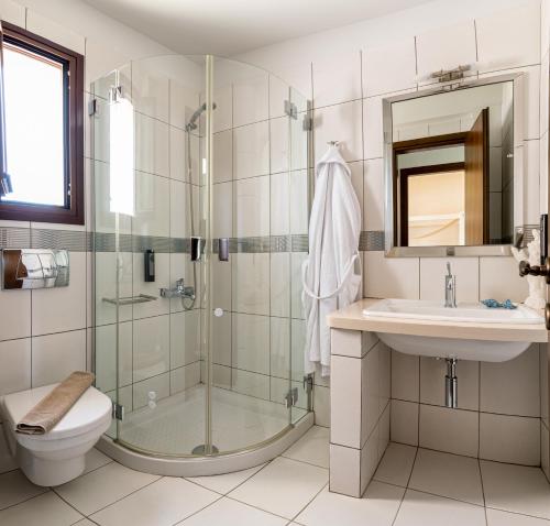 y baño con ducha, aseo y lavamanos. en Pearls Of Crete - Holiday Residences, en Makrí Gialós