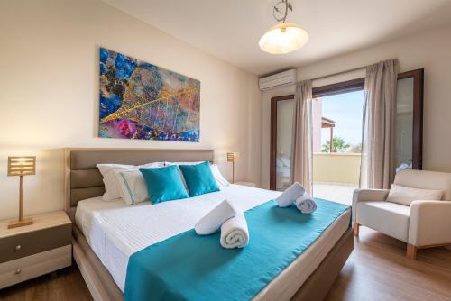 Pearls Of Crete - Holiday Residences في ماكري جيالوس: غرفة نوم بسرير كبير عليها مناشف