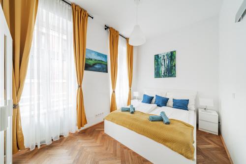 - une chambre blanche avec un lit et des oreillers bleus dans l'établissement 15 C&J's apartment, à Vienne