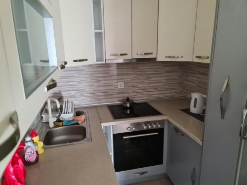 a small kitchen with a sink and a stove at Apartman Jaca in Tuzla