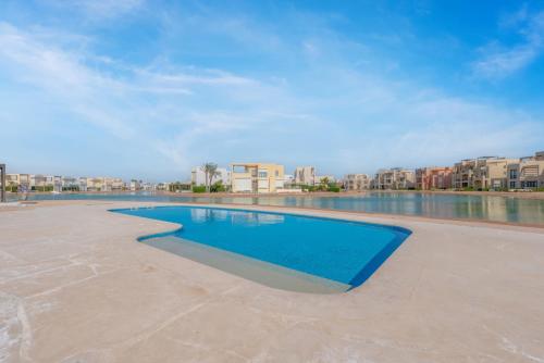 a swimming pool with buildings in the background at Brand-New Family House in Tawila El Gouna Lagoon and Pool Access in Hurghada