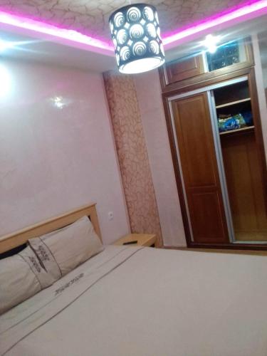 1 dormitorio con cama, luz y ventana en عقارات مرتيل, en Martil