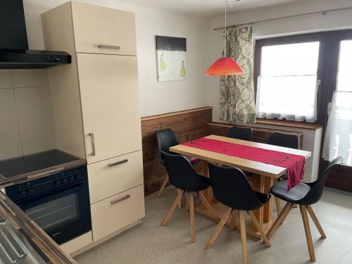 a kitchen with a dining room table and chairs at Oberbichlgut in Flachau