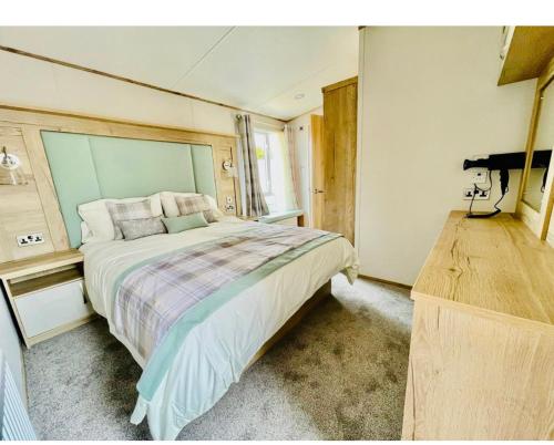 um quarto com uma cama grande e um piano em Prime Location Selsey Chalet Seal Bay em Selsey