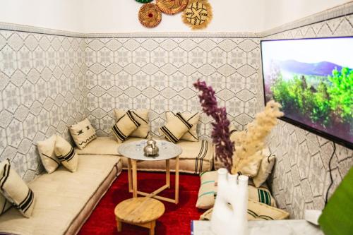 - un salon avec un canapé et une télévision dans l'établissement Riad Fz Marrakech, à Marrakech