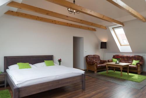 a bedroom with a bed and two chairs and a table at Hotel Pavlov in Pavlov