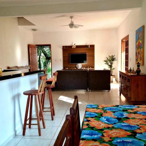 a living room with a couch and a table with chairs at Casa Kauai Boiçucanga in São Sebastião