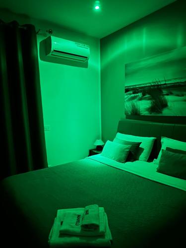 a bedroom with a bed with a green lighting at Marilù in Palermo