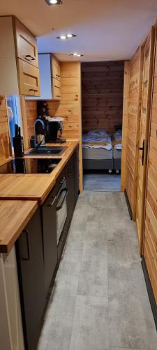 a kitchen with wooden cabinets and a bed in a room at Level780 in Koszarawa