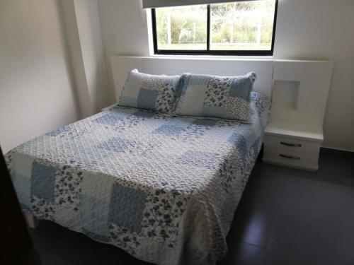 - une chambre avec un lit et une couette bleue et blanche dans l'établissement Casa Campestre Altamira, à Los Curos
