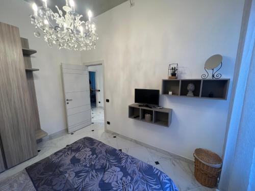 sala de estar con lámpara de araña y pared blanca en APPARTAMENTO DANTE ALASSIO en Alassio
