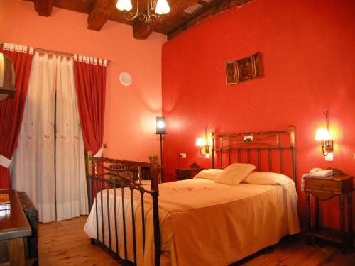 a bedroom with red walls and a bed in a room at La Posada de Carmen in Chañe