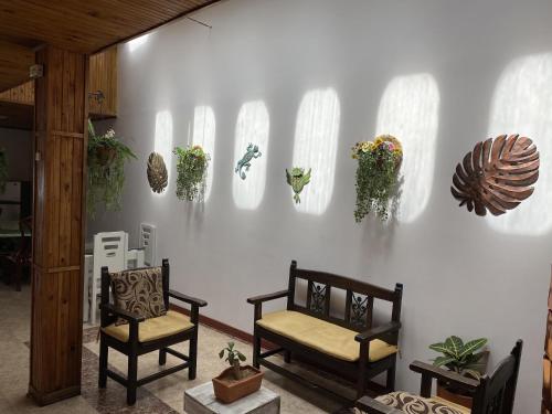 a room with two chairs and plants on a wall at Hermosa Casa en el centro de Santa Rosa de Cabal, sobre vía principal a 3 cuadras de la Plaza in Santa Rosa de Cabal