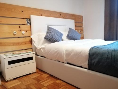a bedroom with a white bed with a wooden wall at Porto Grand Sasimi House in Porto