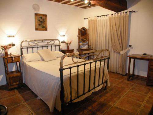 a bedroom with a bed with a metal frame at La Posada de Carmen in Chañe