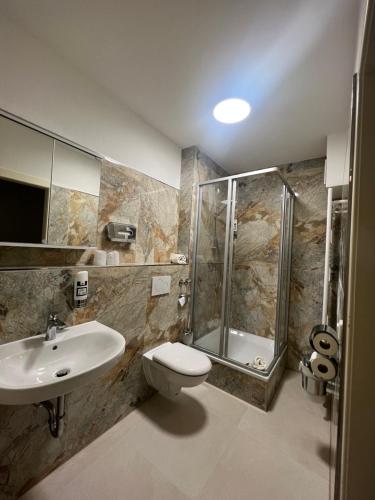 ゼーフェタールにあるM&M Hotel - Seevetalのバスルーム(シャワー、トイレ、シンク付)