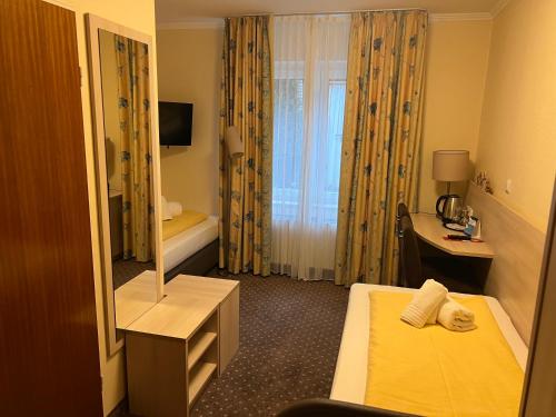a hotel room with a bed and a mirror at M&M Hotel - Seevetal in Seevetal