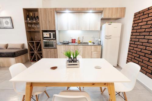 a kitchen with a white table and white chairs at Chacras Wineland Lodge - Casa West in Ciudad Lujan de Cuyo