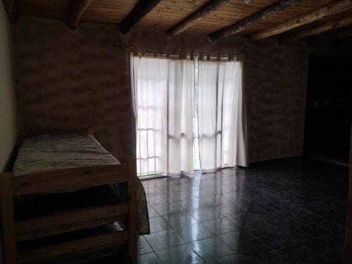 Habitación con ventana y cortina blanca en Casa de campo Sempiterno en Maipú