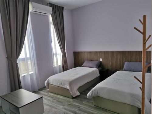 Habitación de hotel con 2 camas y mesa en MersingFirstFloor丰盛港二楼民宿, en Mersing