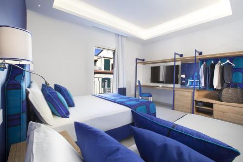 a blue and white bedroom with a bed and chairs at AMORE RENTALS - Appartamento Luis 2 11 in Sorrento