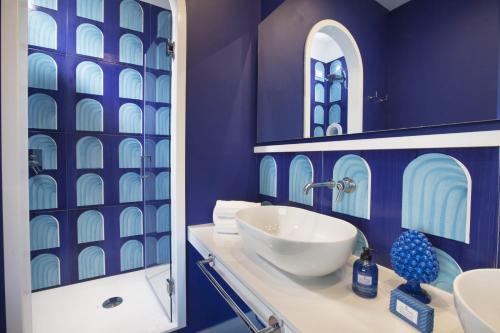 a blue bathroom with a sink and a mirror at AMORE RENTALS - Appartamento Luis 2 11 in Sorrento