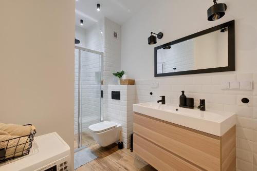 a white bathroom with a sink and a toilet at Targowa 10 Modern 2BR Apt in Warsaw