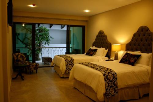 Habitación de hotel con 2 camas y ventana en Hotel Gran David en Santiago de Veraguas