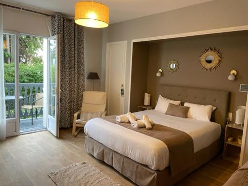 ein Schlafzimmer mit einem großen Bett und einem Balkon in der Unterkunft Hôtel de la Côte Fleurie in Deauville
