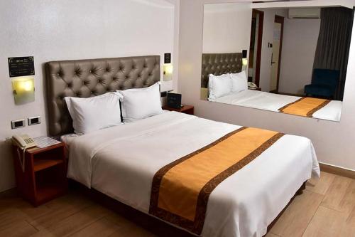 een hotelkamer met 2 bedden en een spiegel bij Serenzza Hotel in Lima