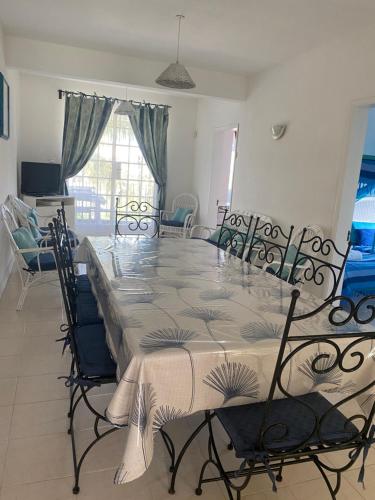 a dining room with a large table and chairs at Résidence Bleu Azur in Grand Baie