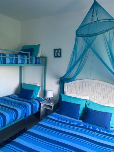 a bedroom with two beds with blue sheets at Résidence Bleu Azur in Grand Baie