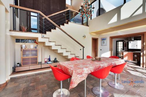a dining room with a table and red chairs at Vivienda Vacacional Casa Erizo adults only in Nazaret