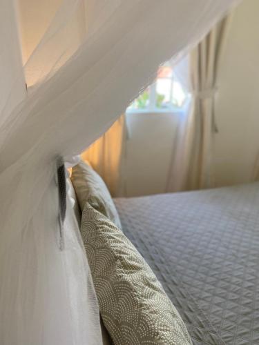 a bed with white sheets and pillows in a bedroom at Résidence Bleu Azur in Grand Baie