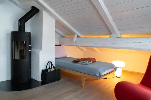 a room with a bed and a fireplace in a attic at Ches'Arsa 2 in La Punt-Chamues-ch