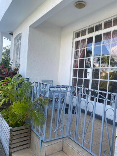 a balcony with chairs and plants in front of a building at Résidence Bleu Azur in Grand Baie
