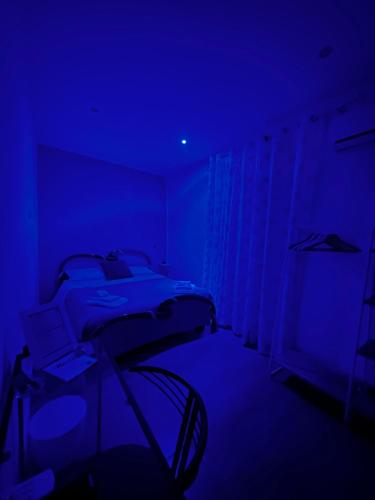 a blue room with a bed with a laptop on it at Marilù in Palermo